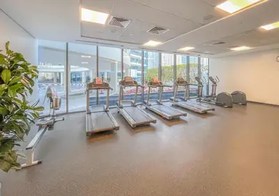a gym with treadmills and a lot of windows at Luxury 1BR Apartment in the heart Marina, Connection to Dubai Marina Mall - Silverene tower in Dubai