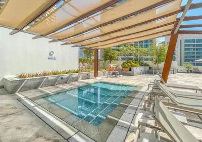 an outdoor swimming pool with a pergola and a building at Luxury 1BR Apartment in the heart Marina, Connection to Dubai Marina Mall - Silverene tower in Dubai