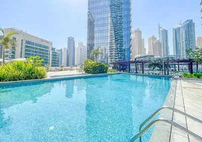 a large swimming pool in a city with tall buildings at Luxury 1BR Apartment in the heart Marina, Connection to Dubai Marina Mall - Silverene tower in Dubai
