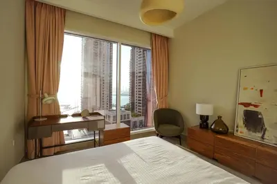 a bedroom with a bed and a desk and a window at Your Elegance at Creek Harbour l 2BR in Dubai
