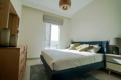 a bedroom with a blue bed and a window at Your Elegance at Creek Harbour l 2BR in Dubai