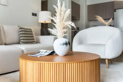 a living room with a table with a vase on it at Downtown Dubai- 2BR Apartment in ACT Towers in Dubai