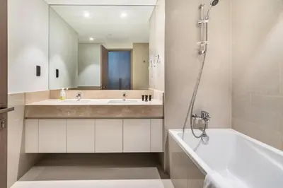 a bathroom with a sink and a tub and a mirror at Downtown Dubai- 2BR Apartment in ACT Towers in Dubai
