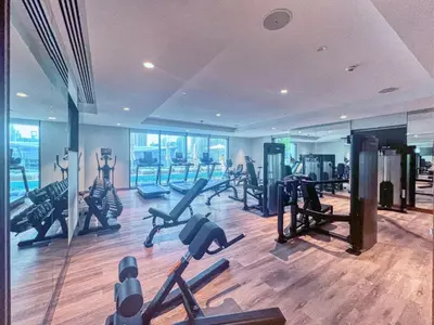 a gym with a bunch of treadmills and exercise bikes at Downtown Dubai- 2BR Apartment in ACT Towers in Dubai