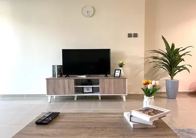 a living room with a flat screen tv on a entertainment center at Lake View 1BR Apt Balcony & Near DMCC Metro in Dubai