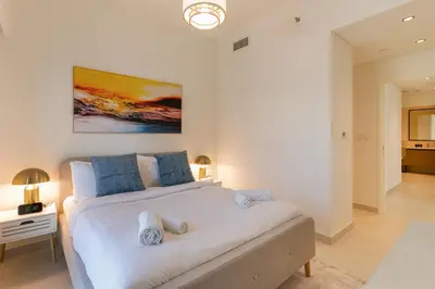 a bedroom with a large white bed with blue pillows at Charming 2BR in Burj Crown, Walk to Burj Khalifa - Allsopp&Allsopp in Dubai