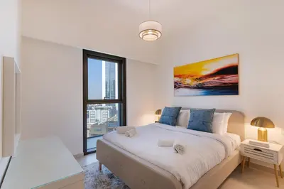 a white bedroom with a large bed and a window at Charming 2BR in Burj Crown, Walk to Burj Khalifa - Allsopp&Allsopp in Dubai
