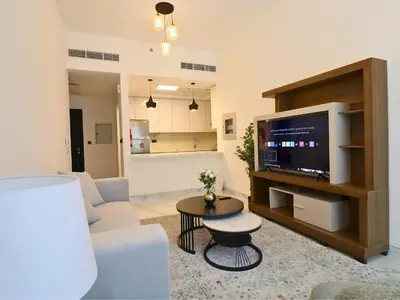 a living room with a couch and a tv at VESTA - Dubai Residence in Dubai