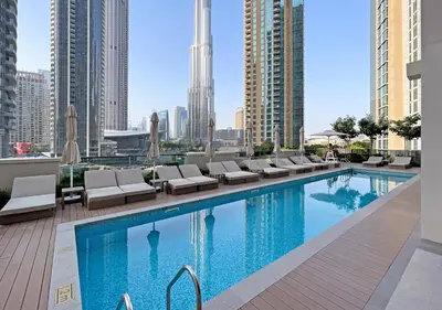 a swimming pool with lounge chairs and a city skyline at Lux 1 BD Apartment, 2 Min walk to Dubai Mall & Burj Khalifa - Act One Tower in Dubai