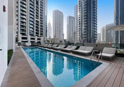 a swimming pool with lounge chairs on the roof of a building at Lux 1 BD Apartment, 2 Min walk to Dubai Mall & Burj Khalifa - Act One Tower in Dubai
