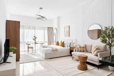 a white living room with a bed and a couch at Silkhaus Bright Studio Near Silicon Central Mall in Dubai