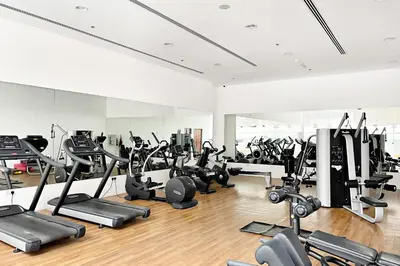 a gym with a lot of treadmills and cardio machines at Silkhaus Bright Studio Near Silicon Central Mall in Dubai