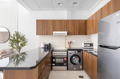 a kitchen with a washer and dryer in it at Silkhaus Bright Studio Near Silicon Central Mall in Dubai