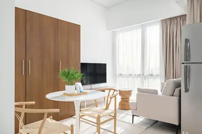 a kitchen and living room with a table and chairs at Silkhaus Luxury Studio in Residential Neighborhood in Dubai