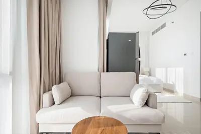 a living room with a white couch and a wooden table at Silkhaus Luxury Studio in Residential Neighborhood in Dubai