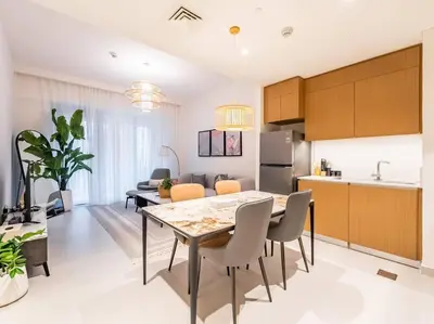 a kitchen and living room with a table and chairs at Zen Oasis : 1BR Splendid Creek Side Retreat - Beach in Dubai
