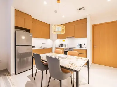 a kitchen with a table and chairs and a refrigerator at Zen Oasis : 1BR Splendid Creek Side Retreat - Beach in Dubai