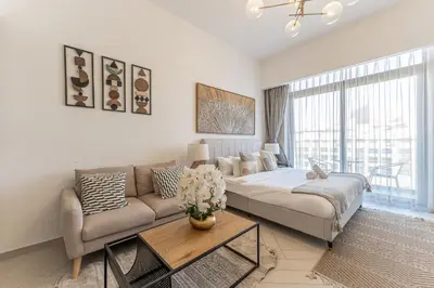 a living room with a couch and a table at HAVN - Smart Home Studio in Oxford 212, JVC in Dubai