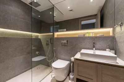 a bathroom with a toilet and a sink and a shower at HAVN - Smart Home Studio in Oxford 212, JVC in Dubai