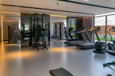a gym with several treadmills and elliptical machines at HAVN - Smart Home Studio in Oxford 212, JVC in Dubai