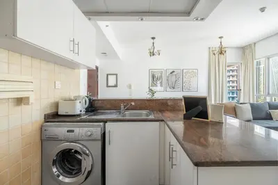 a kitchen with a washing machine and a sink at GuestReady - Bright 1BR with Balcony & Marina View in Dubai