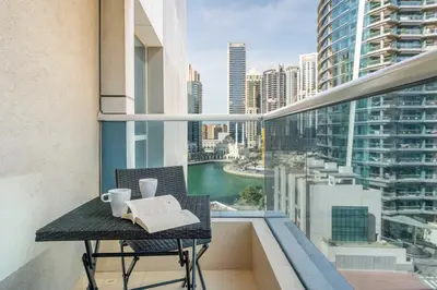 a balcony with a table with a book and cups at GuestReady - Bright 1BR with Balcony & Marina View in Dubai