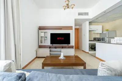 a living room with a tv and a table at GuestReady - Bright 1BR with Balcony & Marina View in Dubai