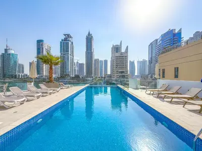 a swimming pool with chairs and a city skyline at Ultra Luxury Dubai Marina I LIV Residence in Dubai