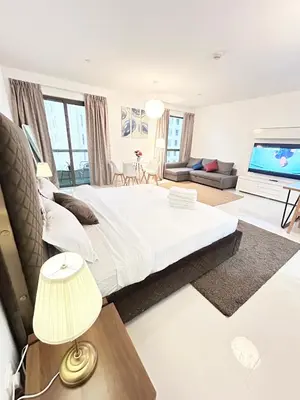 a bedroom with a large bed and a flat screen tv at Seaside Spacious Studio with Vibrant Vibes in JBR By SWEET HOMES in Dubai