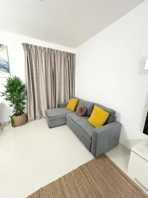 a living room with a gray couch and yellow pillows at Seaside Spacious Studio with Vibrant Vibes in JBR By SWEET HOMES in Dubai
