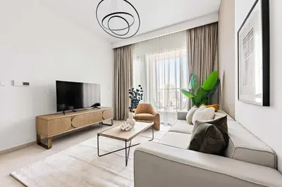 a living room with a couch and a flat screen tv at Silkhaus High Floor 1BDR with View with Pool & Gym in Dubai