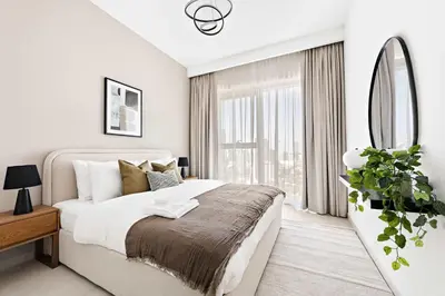 a white bedroom with a large bed and a window at Silkhaus High Floor 1BDR with View with Pool & Gym in Dubai