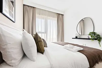 a bedroom with a large bed with pillows and a mirror at Silkhaus High Floor 1BDR with View with Pool & Gym in Dubai