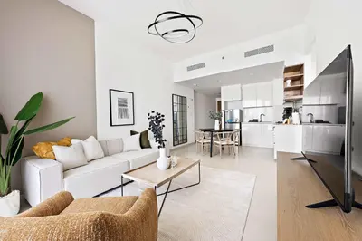 a white living room with a couch and a table at Silkhaus High Floor 1BDR with View with Pool & Gym in Dubai