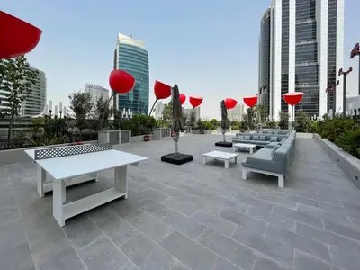 a patio with couches and tables and red umbrellas at GuestReady – Downtown Studio l City View l Balcony in Dubai