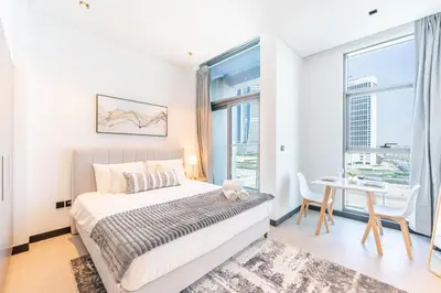 a bedroom with a bed and a table with chairs at HAVN - Studio Unit in 15 Northside, Business Bay in Dubai
