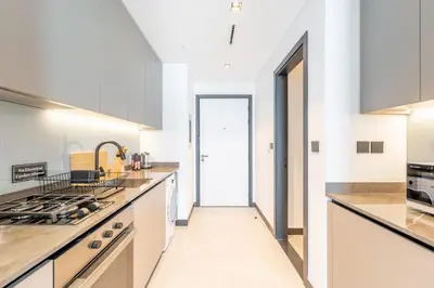 a kitchen with white cabinets and a stove top oven at HAVN - Studio Unit in 15 Northside, Business Bay in Dubai
