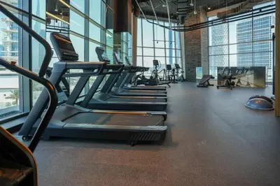 a gym with rows of treadmills and machines at HAVN - Studio Unit in 15 Northside, Business Bay in Dubai