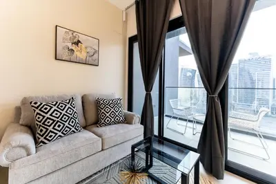 a living room with a couch and a large window at HAVN - Studio in Business Bay, Burj Khalifa View in Dubai