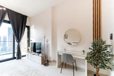 a white room with a desk and a mirror at HAVN - Studio in Business Bay, Burj Khalifa View in Dubai