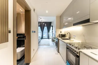a kitchen with a sink and a stove at HAVN - Studio in Business Bay, Burj Khalifa View in Dubai