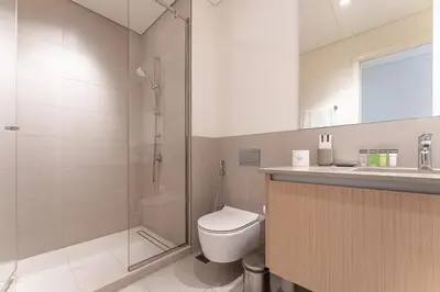a bathroom with a shower and a toilet and a sink at HAVN - 2 Bedroom in Bayshore, Dubai Creek Harbour in Dubai