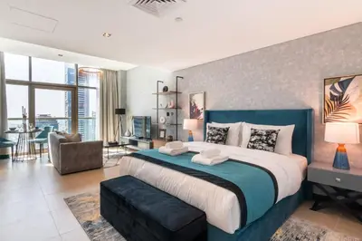 a bedroom with a large bed and a living room at GuestReady- Holiday Homes - Cyan Sky View in Dubai