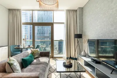 a living room with a couch and a large window at GuestReady- Holiday Homes - Cyan Sky View in Dubai