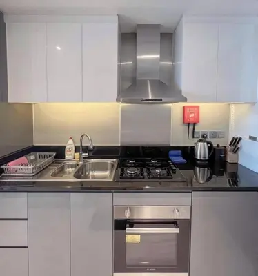 a kitchen with a sink and a stove top oven at Deluxe Studio Business Bay - Canal View - Gym & Pool in Dubai