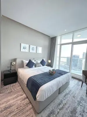 a bedroom with a large bed and a large window at Deluxe Studio Business Bay - Canal View - Gym & Pool in Dubai