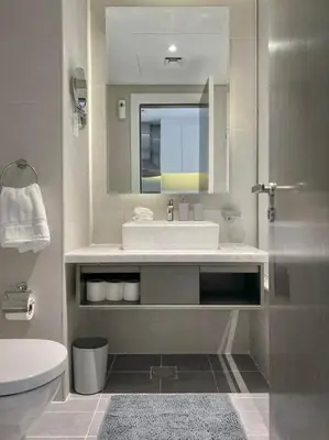 a bathroom with a sink and a toilet and a mirror at Deluxe Studio Business Bay - Canal View - Gym & Pool in Dubai