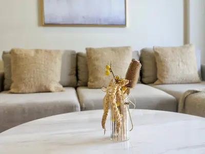 a glass vase with flowers in it on a table at Ambient 1BR Apartment On The Beach at 5 Star Resort in Dubai