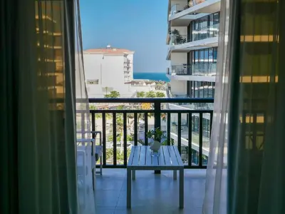 a balcony with a table and a view of the ocean at Ambient 1BR Apartment On The Beach at 5 Star Resort in Dubai