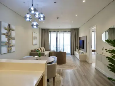 a living room with a couch and a table at Ambient 1BR Apartment On The Beach at 5 Star Resort in Dubai